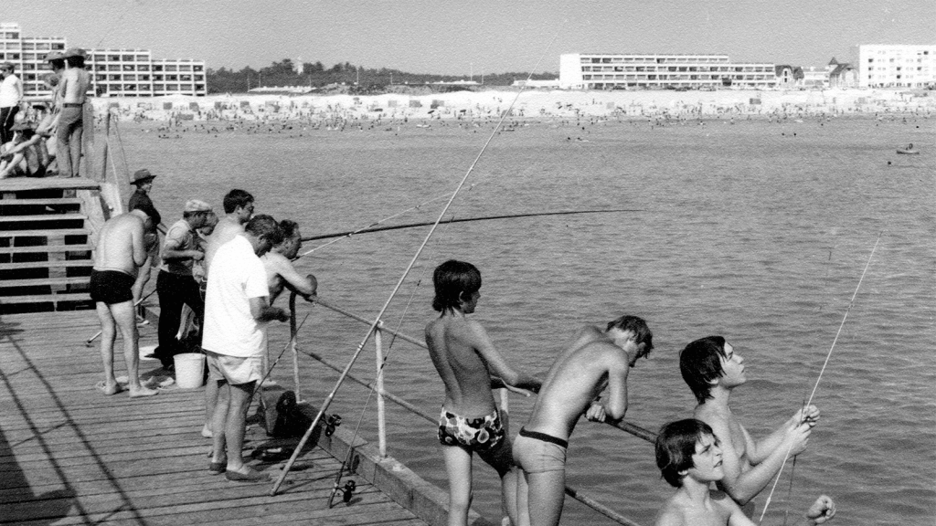 Photo de l'estacade en noir et blanc, avec des prêcheurs et des enfants s'accrochant à la barrière. Photo d'archive