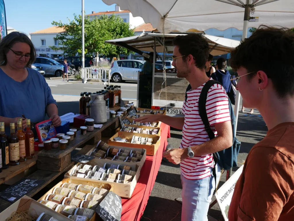 photos de vacanciers au marché de producteurs de la barre de monts fromentine, discutant avec un producteur