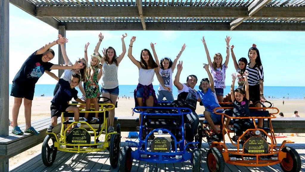 un groupe d'enfants sur des rosalies sous les pergolas de notre dame de monts