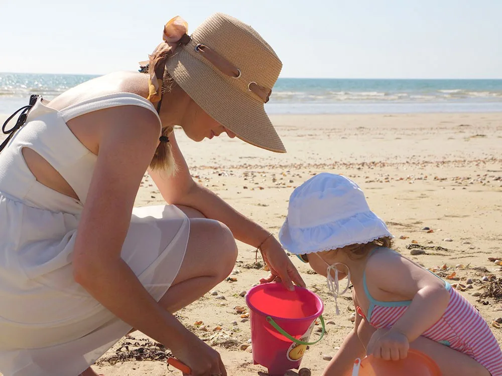 enfant jouant dans le sable avec un adulte