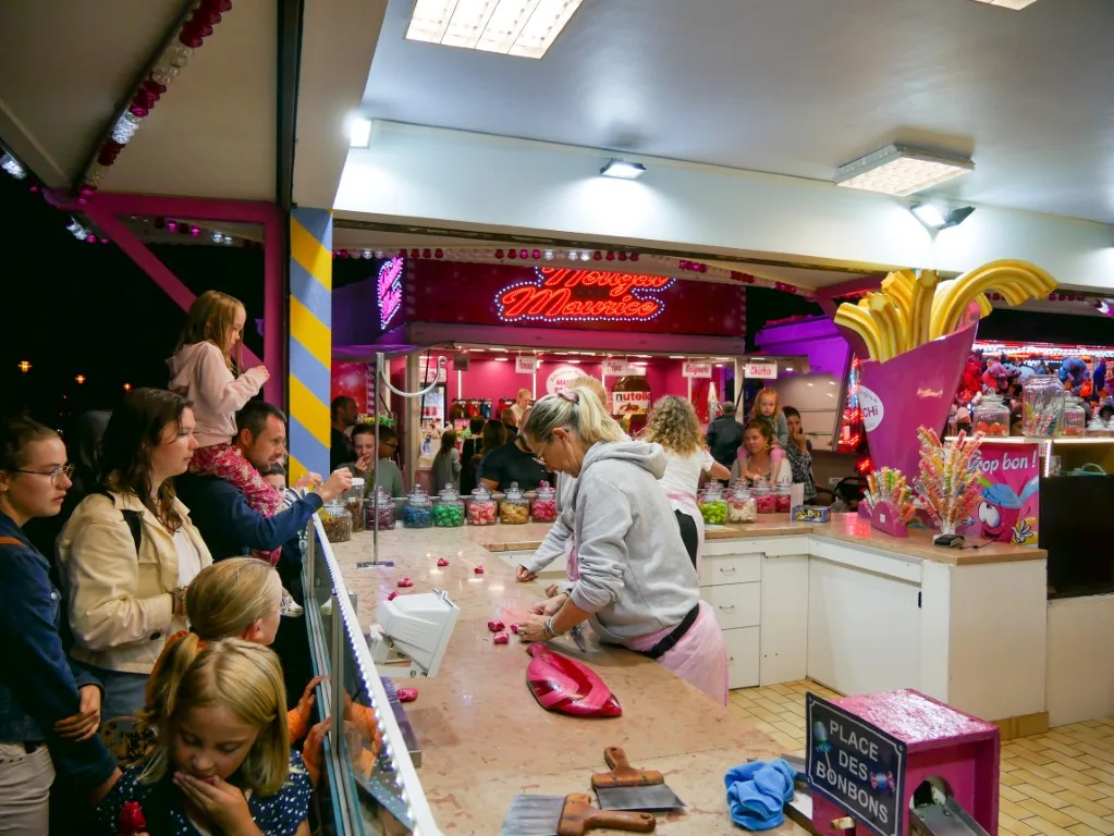 Un stand de confiseries avec une femme fabriquant les bonbons au Pays de Saint Jean de Monts