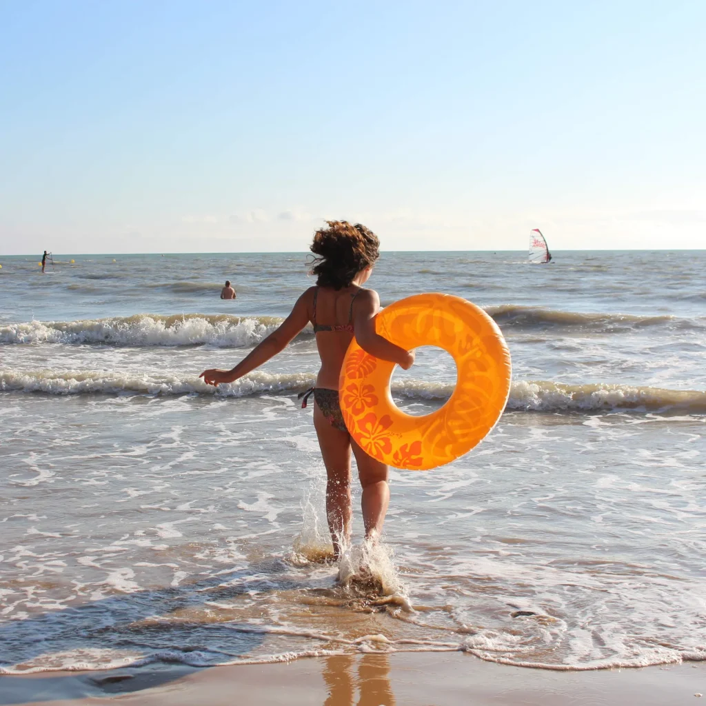 Jeune femme avec une bouée sur la plage