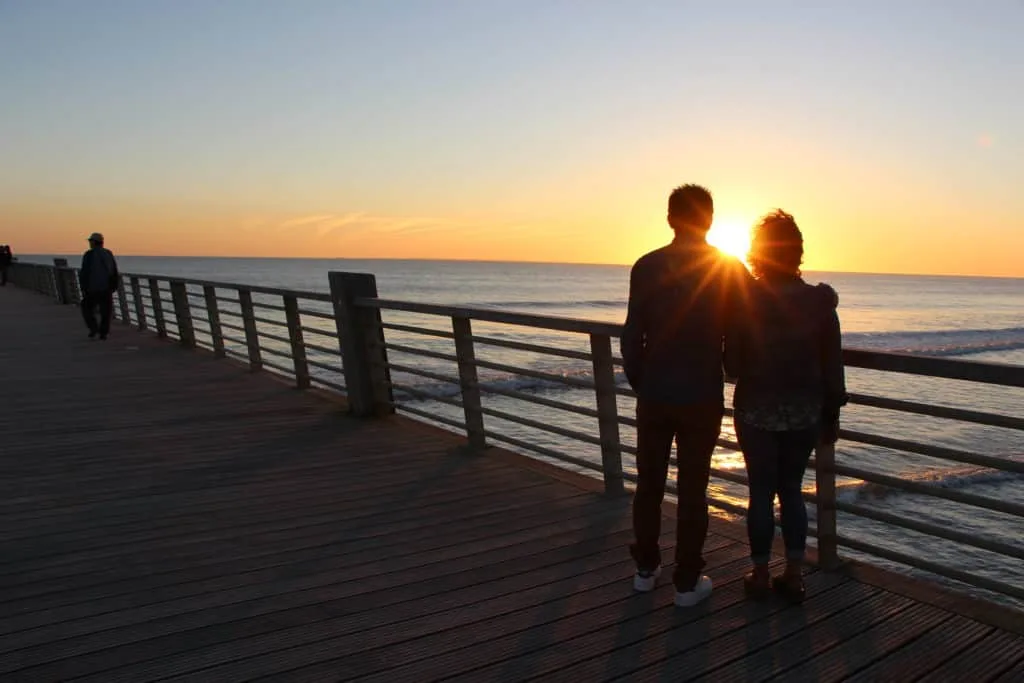 photo d'un couple se promenant sur l'estacade de saint jean de monts au coucher du soleil
