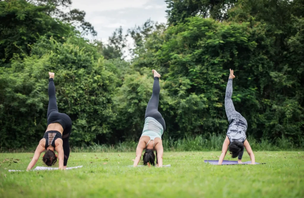 trio de femmes faisant une posture de yoga dans la forêt