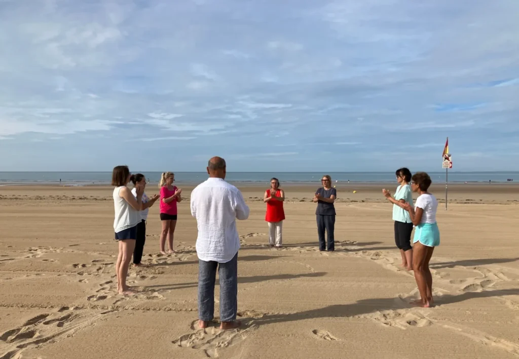 groupe de personnes faisant un cours de yoga sur la plage de saint jean de monts