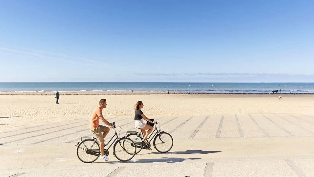 deux personnes se promenant à vélo sur l'esplanade de saint jean de monts