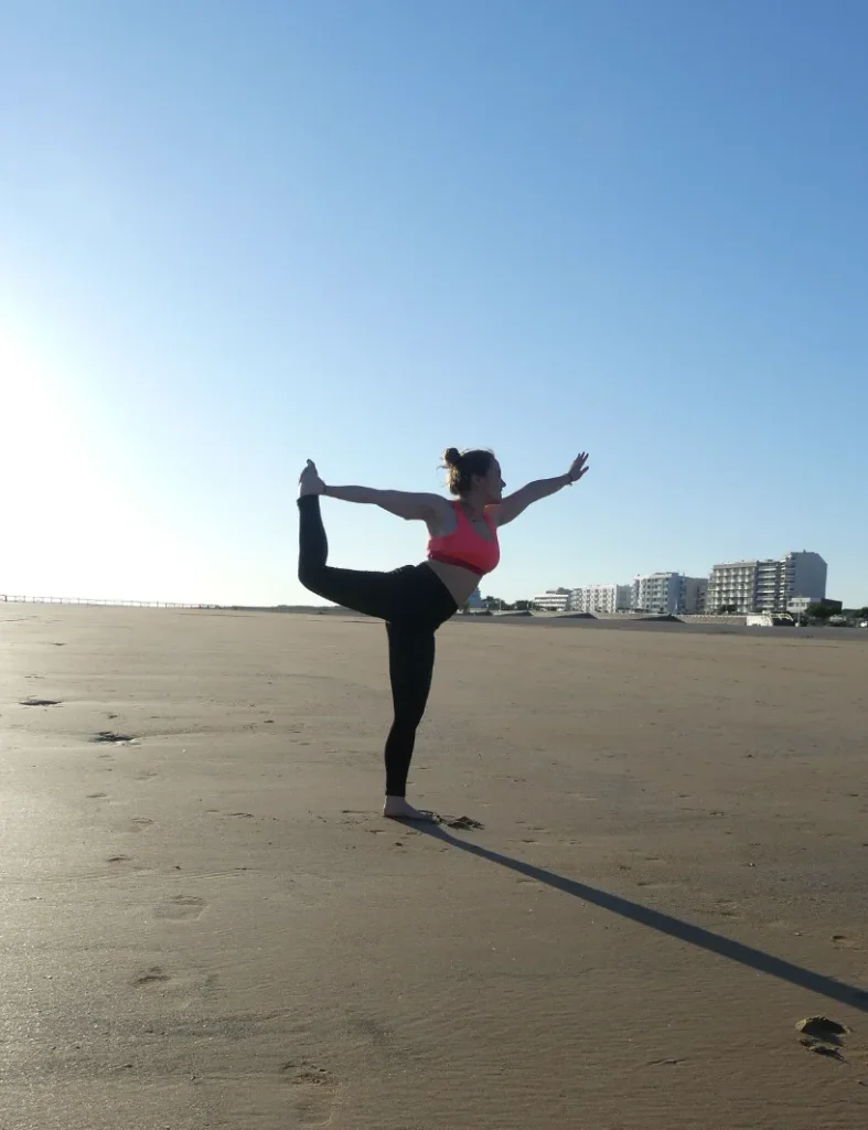Femme faisant une posture de yoga sur la plage de saint jean de monts