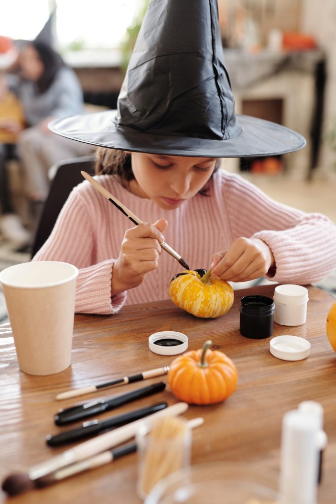 petite fille décorant une citrouille pendant un atelier de décoration de cucurbitacées pendant le festival Ci t'as la trouille à saint jean de monts