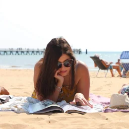 Jeune femme lisant un magazine sur la plage de Saint Jean de Monts