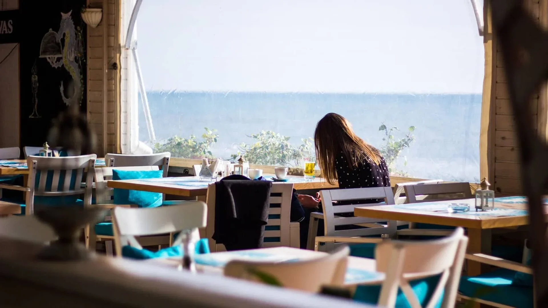 femme assise dans un restaurant en bord de mer