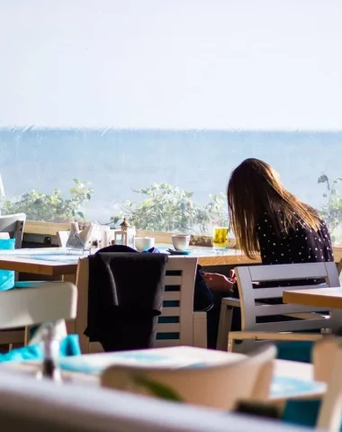 femme assise dans un restaurant en bord de mer