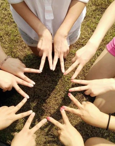 Enfants d'une association faisant une étoile avec leurs doigts
