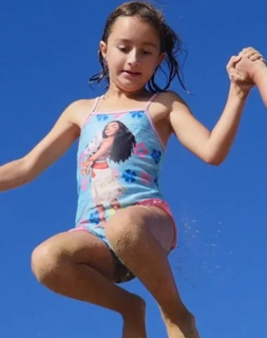 trois enfants sautant dans le sable sur une plage du pays de saint jean de monts