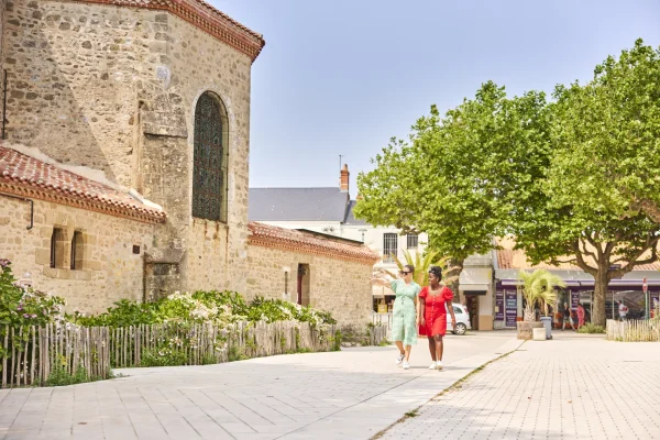 photo de l'église de saint jean de monts et deux touristes passant à côté