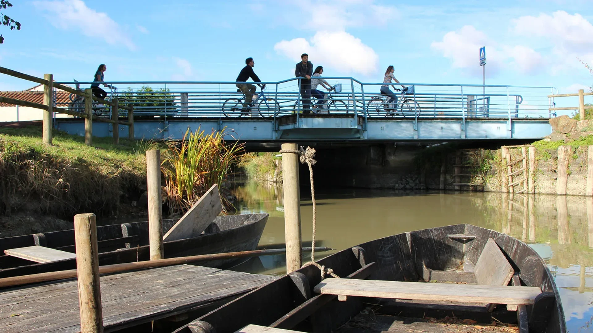 4 personnes faisant du vélo sur un pont au perrier et une personne qui regarde à l'horizon