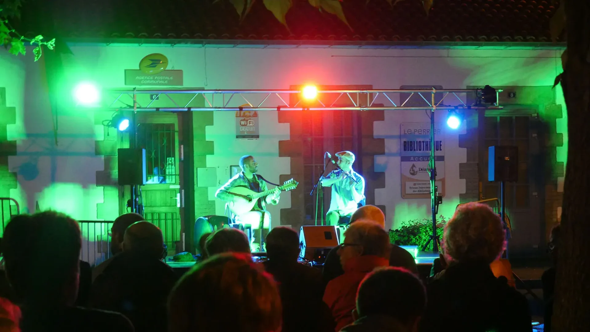 un duo d'hommes fait un concert avec chant et guitare au Perrier