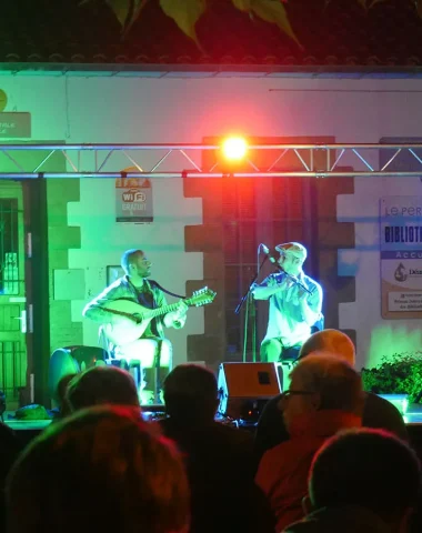 un duo d'hommes fait un concert avec chant et guitare au Perrier