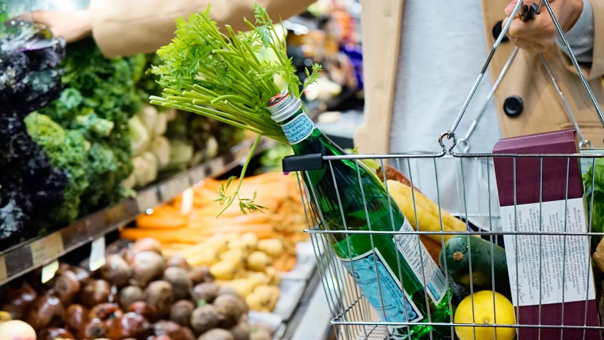 image d'une femme avec un panier qui fait ses courses dans un commerce au Perrier. Elle achète notamment des légumes et de l'eau.