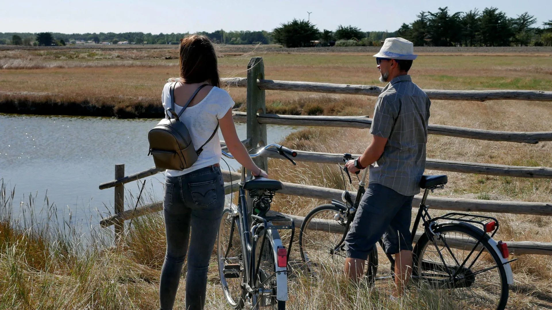 deux personnes à vélo dans les marais de la barre de monts fromentine qui contemplent l'horizon