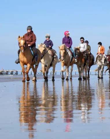 photo d'un groupe faisant une balade à cheval sur la plage de la barre de monts - fromentine