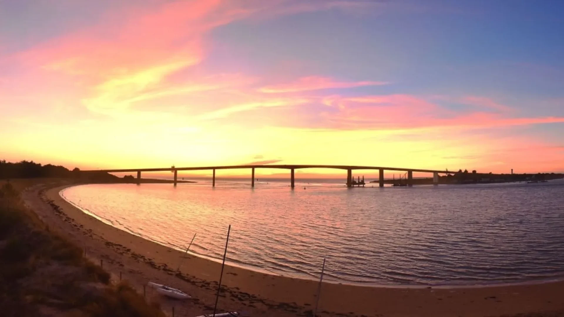 photo de la plage de fromentine avec le coucher de soleil derriere le pont de noirmoutier