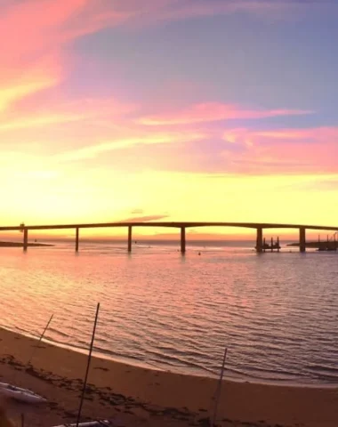 photo de la plage de fromentine avec le coucher de soleil derriere le pont de noirmoutier