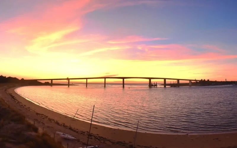 photo de la plage de fromentine avec le coucher de soleil derriere le pont de noirmoutier