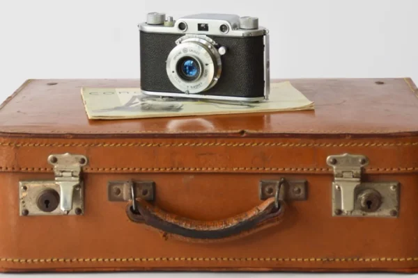 photo d'une valise et d'un appareil posé dessus invitant au voyage et aux services de conciergeries de la barre de monts - fromentine