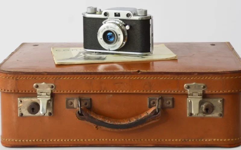 photo d'une valise et d'un appareil posé dessus invitant au voyage et aux services de conciergeries de la barre de monts - fromentine